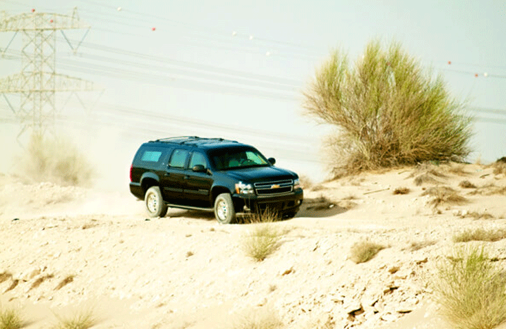 Side view of Chevrolet Suburban SUV parked on the right side.