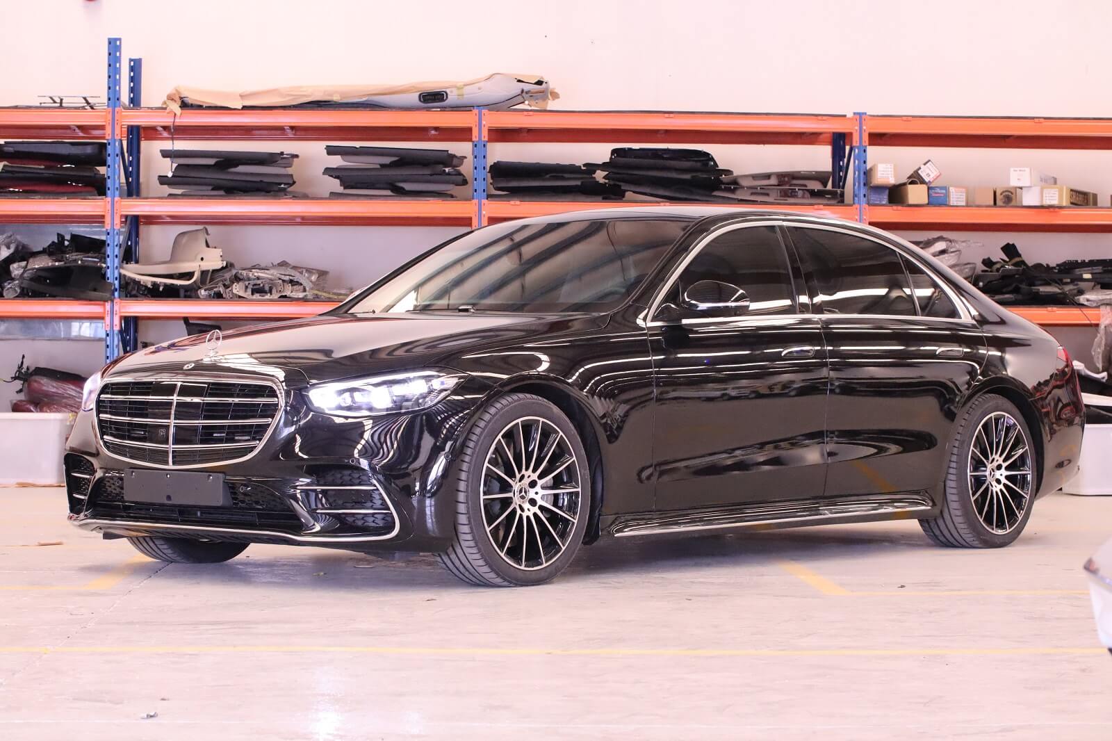 Mercedes-Benz S500 armored luxury sedan front left view with lights on