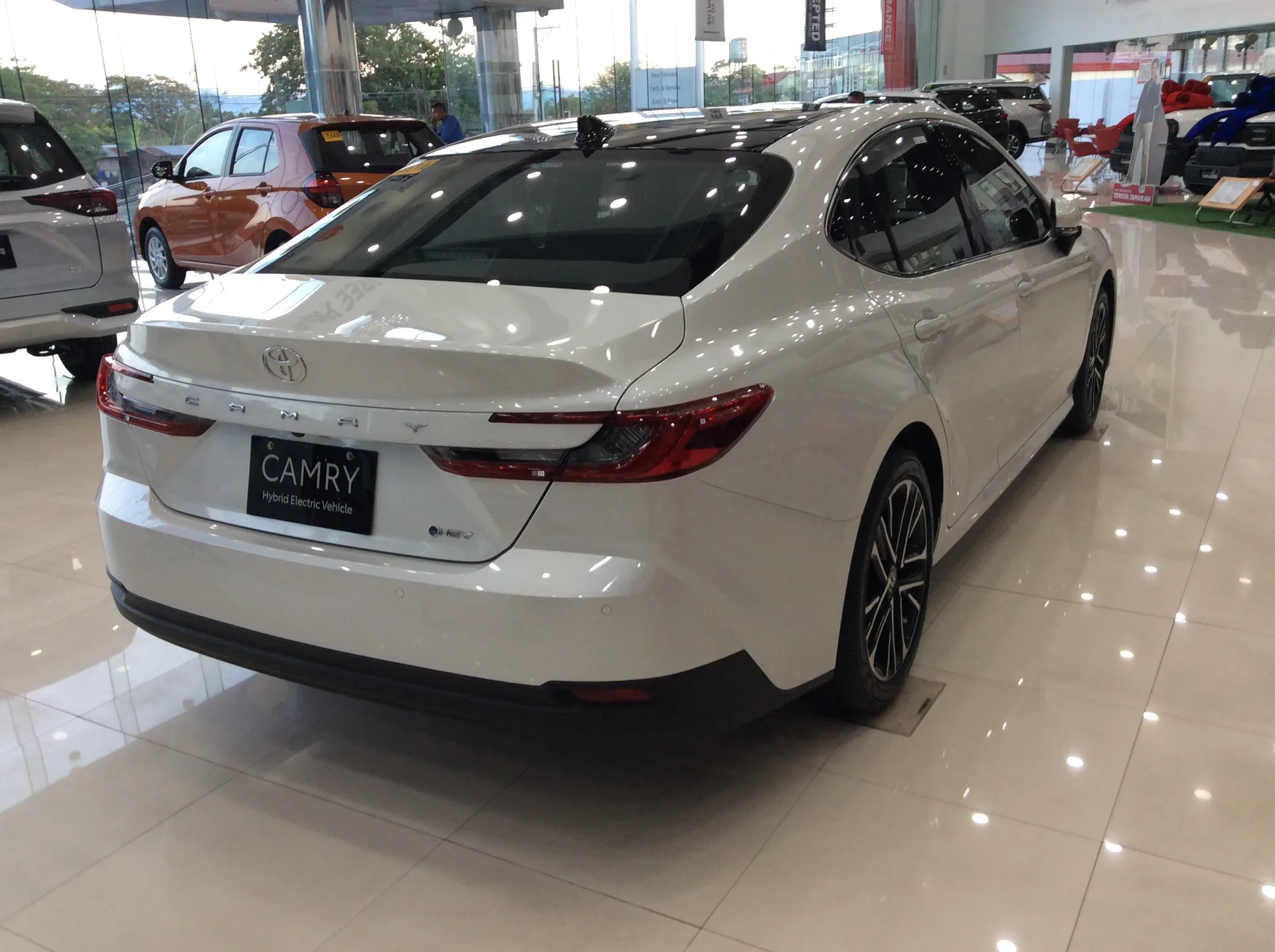 White current-generation Toyota Camry shown from the rear right