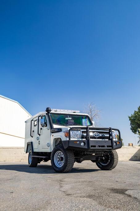 Toyota LC79 Troop Carrier with bull bar and snorkel under clear blue sky
