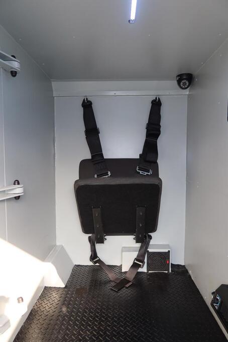 Toyota LC79 personnel compartment with wall-mounted fold-down seat and safety straps