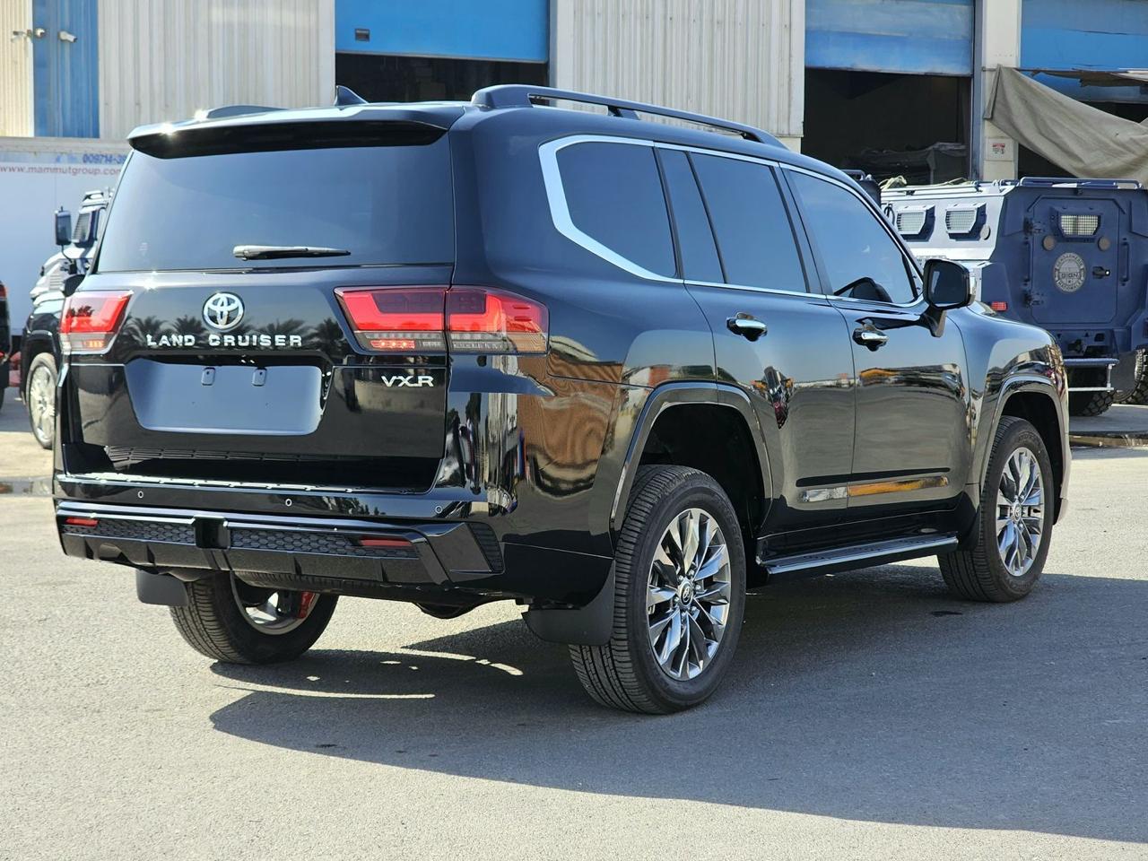 Toyota Land Cruiser 300 VXR rear angle view with black exterior, chrome trim and LED taillights